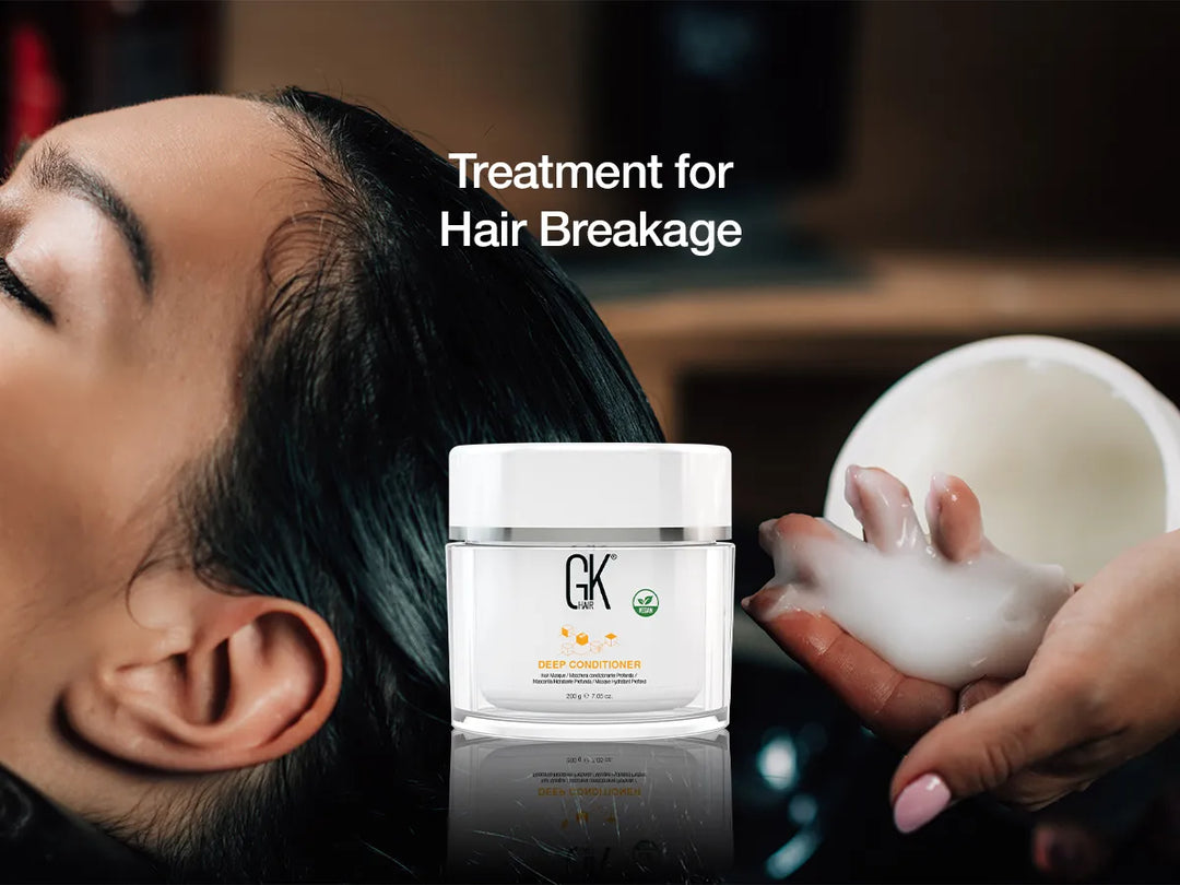 A woman receiving a hair treatment while holding a jar of GK Deep Conditioner, labeled for hair breakage repair.