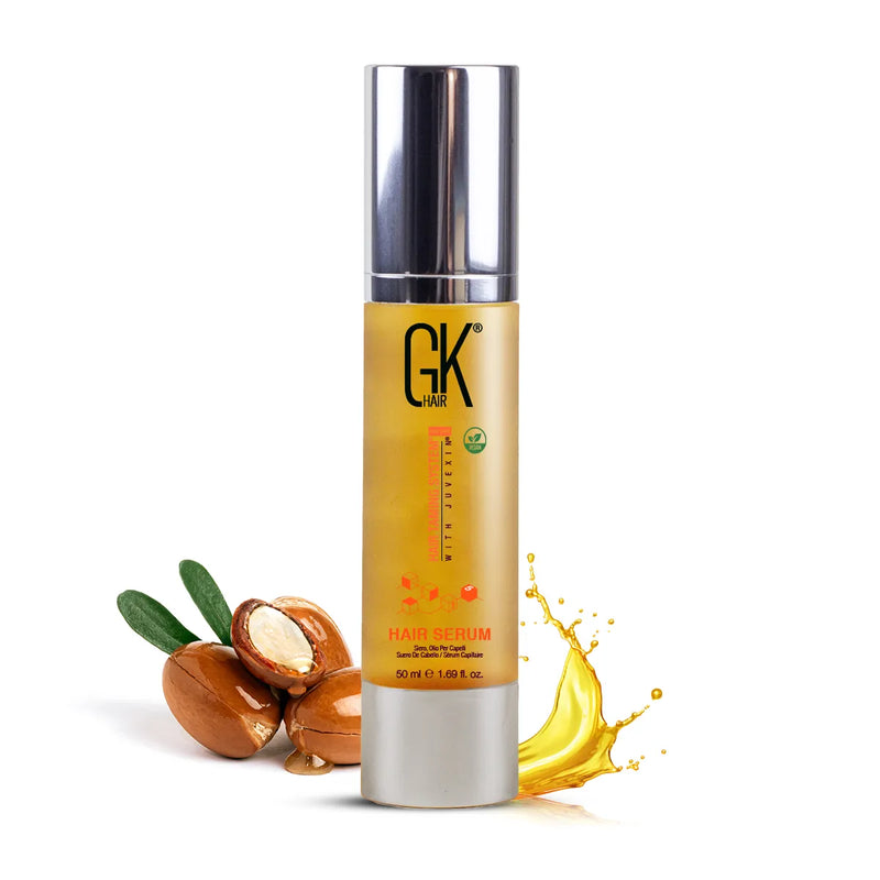 GK Hair Serum Pro 50 ml Hair Serum bottle with silver cap beside argan nuts and an oil splash