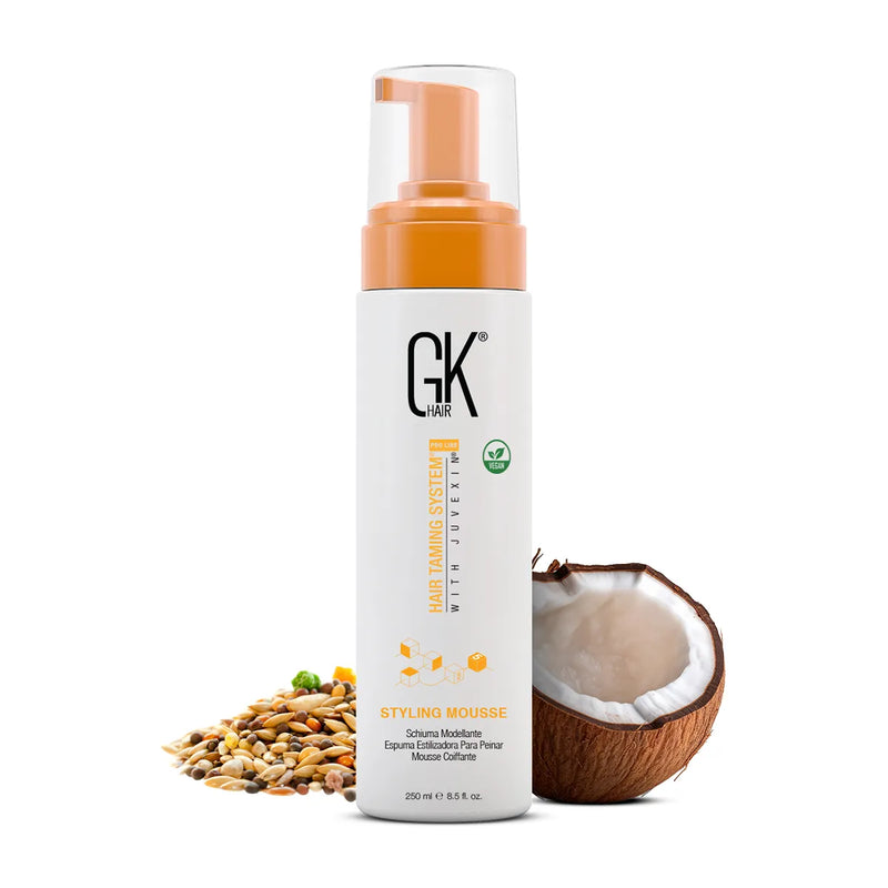 GK Hair Styling Mousse Pro 250 ml pump bottle, front view with a halved coconut and natural seeds