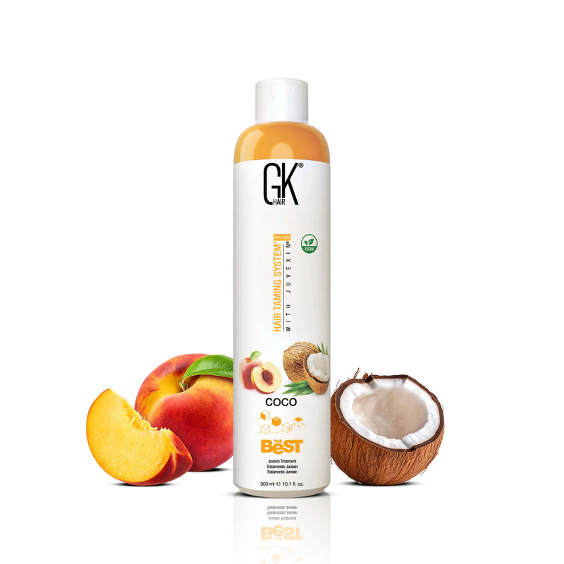 GK Hair The Best Vegan Hair Treatment Pro Coco 300 ml bottle beside peaches and a halved coconut